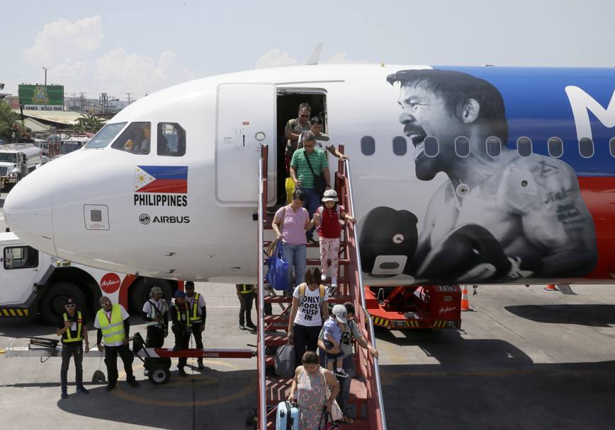 L&#39;AirAsia, per mostrare il proprio sostegno a Manny Pacquiao, ha dipinto il volto e il nome del pugile filippino sulla carlinga di un Aibus A320. Nella foto lo sbarco di un volo interno appena atterrato a Manila. Reuters